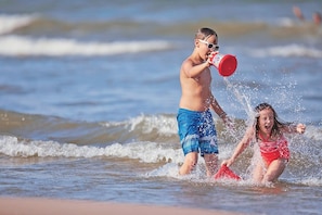 Two children playing in the water at the beach.