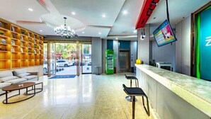 A modern hotel lobby with a reception desk, seating area, and a large bookshelf. - Core Clould of hotel (Nanchang County)