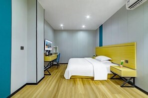 A hotel room with a bed, bedside table, desk, chair, and a wall-mounted air conditioner. - Core Clould of hotel (Nanchang County)