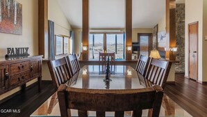 A spacious dining area with a high ceiling and large windows offering a view of the landscape. - Ski-In/Ski-Out Mountain Retreat with Pool and Private Indoor Hot Tub (Granby)