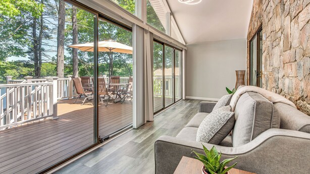 Et moderne interiør med en stor skydedør, der fører ud til en terrasse.