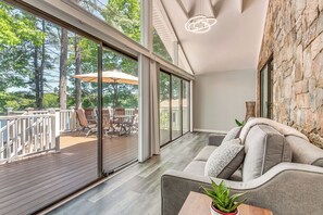Um interior moderno com uma ampla porta de vidro deslizante que dá para um deck externo.