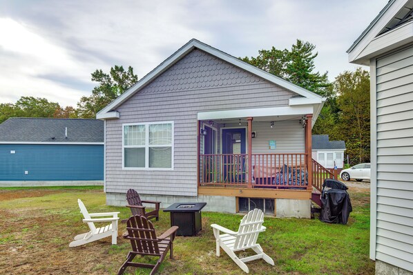 A small house with a porch, two Adirondack chairs, and a fire pit. - 2 Mi to Moody Beach, Amenity Access: Wells Getaway (Wells)