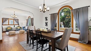 A dining area with a wooden table, black chairs, and a chandelier. - Casa Italiana - Charming Home in Little Italy (San Diego)