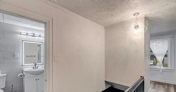 A bathroom with a white sink, mirror, and toilet. - Harmony Suites II 
 (Mount Pocono)