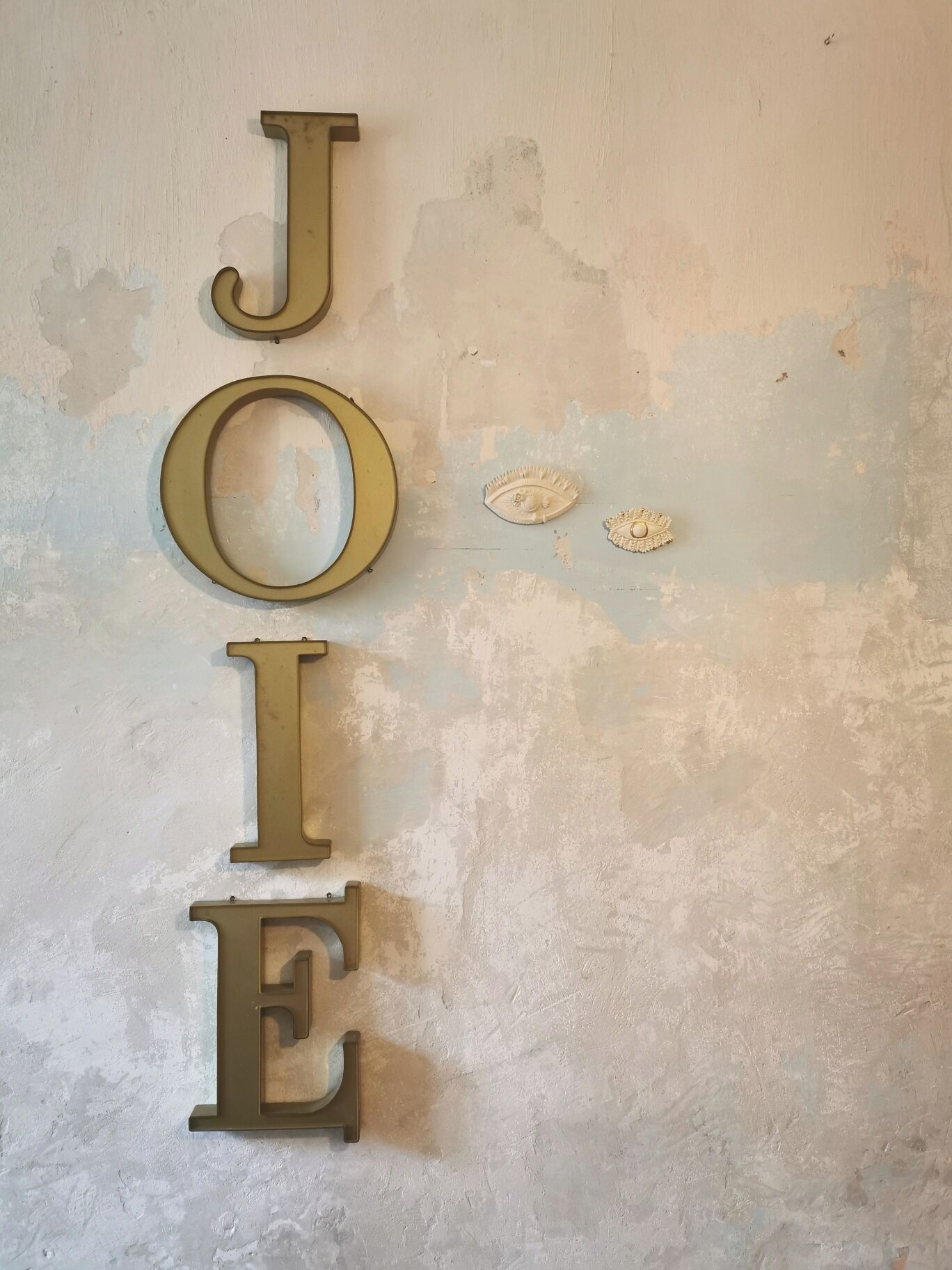 Een muur met de naam 'JOE' in grote, gouden letters.
