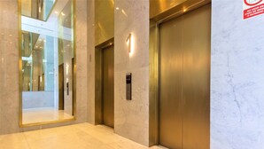 A modern elevator with a marble wall and a reflective floor. - Redibuk - Beautiful apart 2 BR Barranco (Lima)