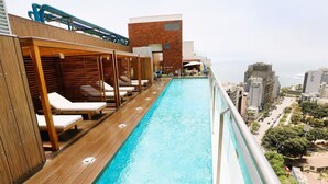 A rooftop pool with wooden loungers and a view of the city. - Redibuk - Beautiful apart 2 BR Barranco (Lima)