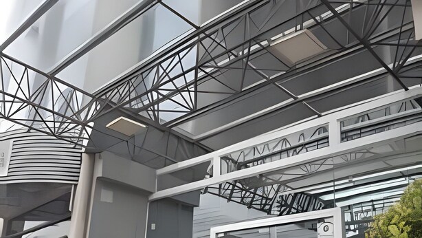 A modern building with a glass facade, a metal framework, and a visible entrance with a glass door. - Saint Sebastian ap101-stúdio  (Jaragua do Sul)