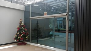 A modern building with a glass entrance and a decorative Christmas tree. - Saint Sebastian ap101-stúdio  (Jaragua do Sul)