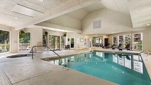 A large indoor swimming pool with clear water, surrounded by lounge chairs and a bench. - End Unit; Ocean Peek; 5th floor - Villamare. 2 hrs Pickleball/Tennis per day! (Hilton Head Island)