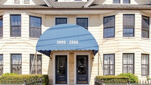 A building with a blue awning displaying the numbers 2886-2888. - Modern Apartment in Black Rock (Bridgeport)
