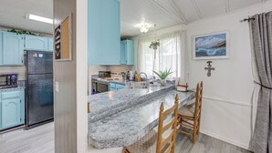 A kitchen with a granite countertop, a refrigerator, and light blue cabinets. - Lakefront Gun Barrel City Home w/ Dock & Deck (Gun Barrel City)