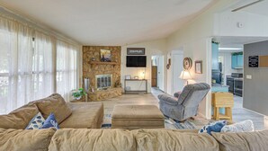 A spacious living room with a stone fireplace, a flat-screen TV, and a comfortable seating area. - Lakefront Gun Barrel City Home w/ Dock & Deck (Gun Barrel City)