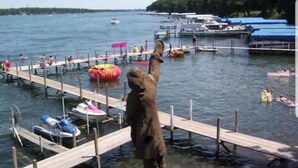 Un quai où sont amarrés des bateaux et où des personnes pratiquent des activités nautiques.