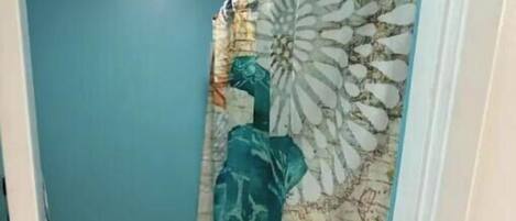 Une salle de bain équipée de toilettes, d’un lavabo et d’un rideau de douche orné d’un motif représentant une tortue de mer.