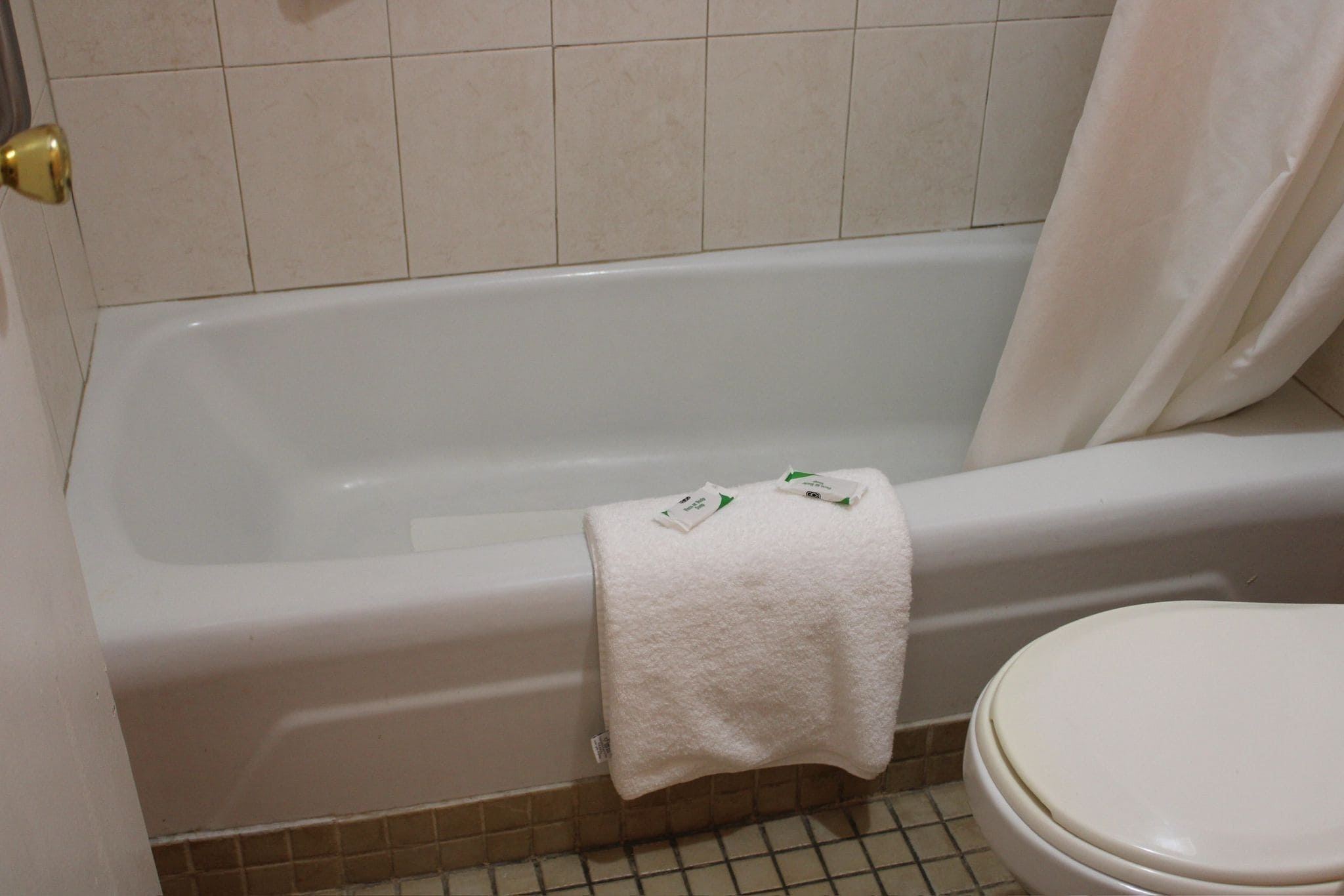Un bagno con una vasca, un water e una tenda per la doccia.