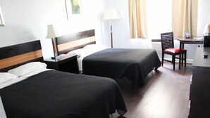 A hotel room with two beds, a desk, a chair, and a lamp. - Executive Economy Lodge (Pompano Beach)