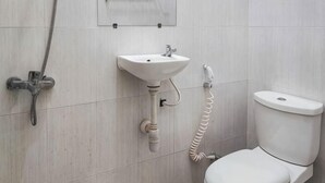 Un baño con inodoro, lavabo y ducha.