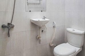 A bathroom with a toilet, sink, and shower. - RedDoorz @ Tanakatto Homestay Waikabubak (Waikabubak City)