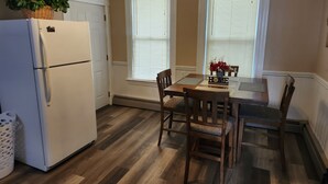 A kitchen with a refrigerator, dining table, chairs, and a potted plant. - Very spacious, clean, and comfortable first floor unit. Close to major highway!  (Manchester)