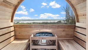 A sauna with a wooden interior and a view of the ocean.