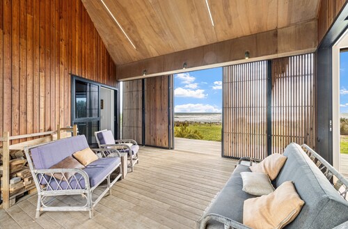 Sauna, seafront, and architecture steps away from the Tasman Sea