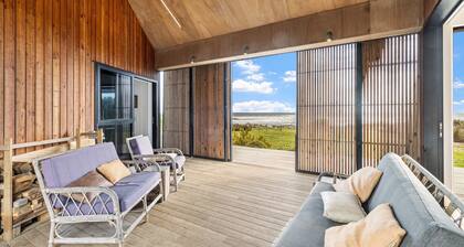 Sauna, seafront, and architecture steps away from the Tasman Sea