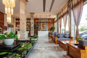 A hotel lobby with a reception desk, seating area, and potted plants. - Elong R.YUN Hotel (Tiantaishan High-Speed Railway Station) (Tiantai County)