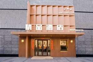 A hotel entrance with a modern facade, signage, and a welcoming entrance. - Shangcheng Business Hotel (Korla)