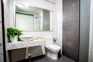 A modern bathroom with a marble sink, a toilet, and a shower. - Shangcheng Business Hotel (Korla)