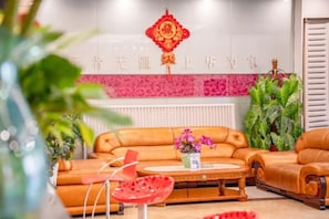 A modern interior with a leather sofa, a coffee table, and a decorative red hanging ornament.