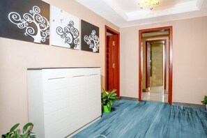A hallway with a white radiator, a blue floor, and three black and white wall art pieces.