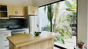 A modern kitchen with wooden cabinets, a stainless steel refrigerator, and a gas stove.