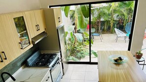A compact kitchen with a gas stove, a sink, and a dining area with a table and chairs.