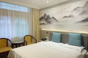 Une chambre d’hôtel avec un lit, deux chaises, une table de chevet et une fresque murale.