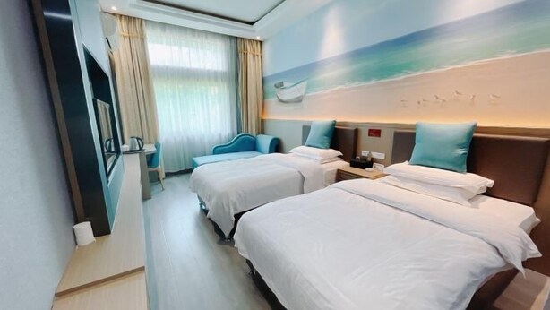 Habitación de hotel con dos camas, televisión, escritorio y un cuadro con una escena de playa.