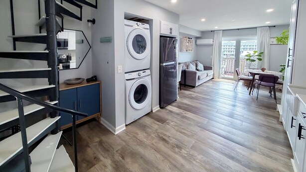 Un appartement moderne comprenant une cuisine, un coin repas, un salon et un escalier.