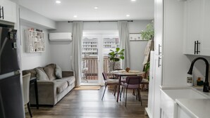 Un appartement moderne comprenant un coin repas, une cuisine et un balcon avec vue.