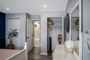 A bedroom with a bed, bedside table, and a mirror.