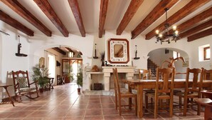 A spacious dining area with wooden furniture, a fireplace, and exposed wooden beams. - TONI MOSCA. Superb villa close to Pollensa (Pollensa)