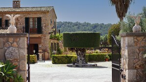 A stone building with a well-maintained garden, a statue, and a gate. - TONI MOSCA. Superb villa close to Pollensa (Pollensa)