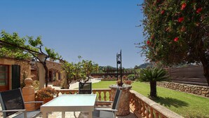 An outdoor patio with a table and chairs, a stone balustrade, and a view of a garden and distant hills. - TONI MOSCA. Superb villa close to Pollensa (Pollensa)