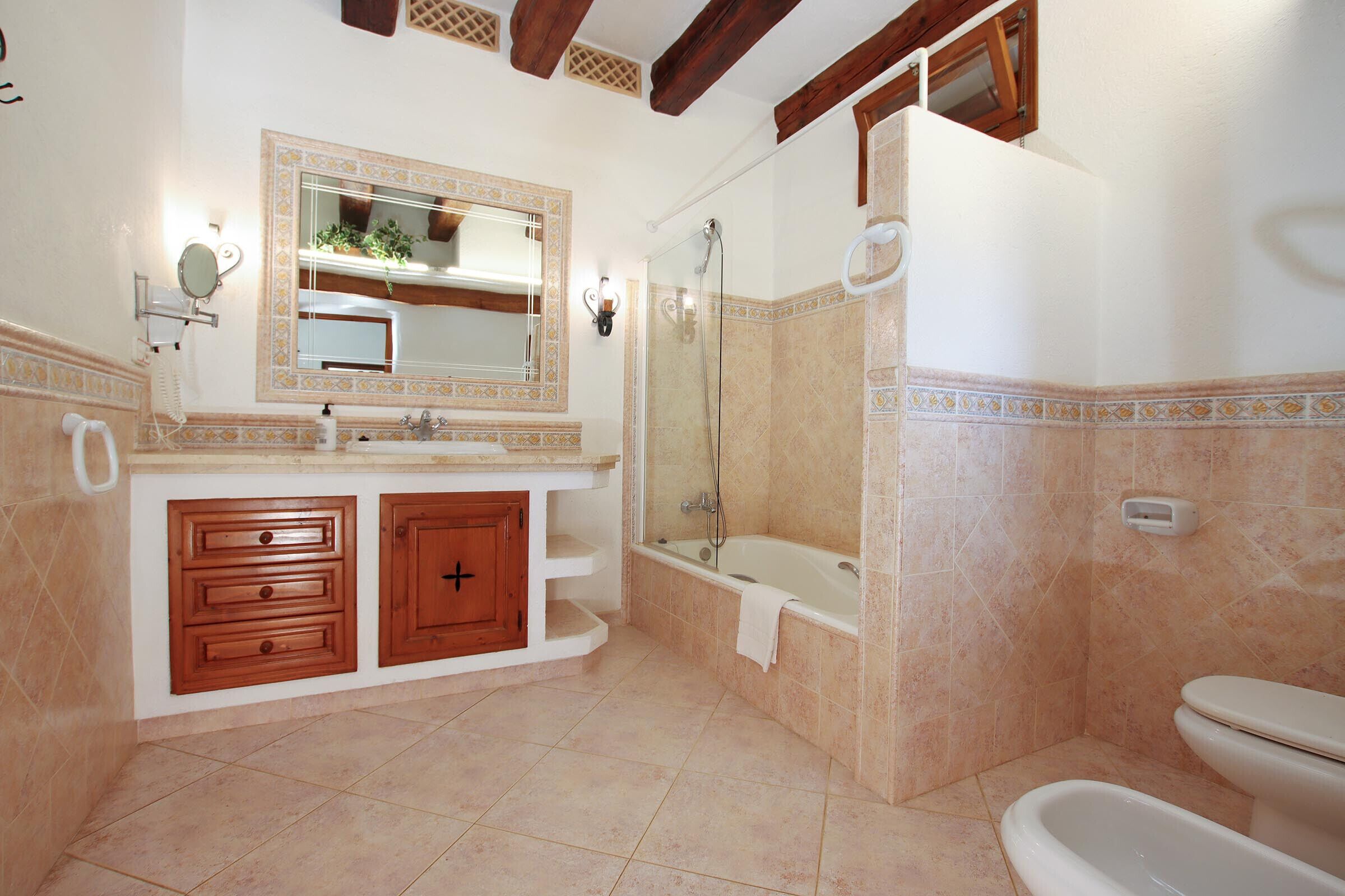 Un baño con bañera, inodoro y tocador con cajones.