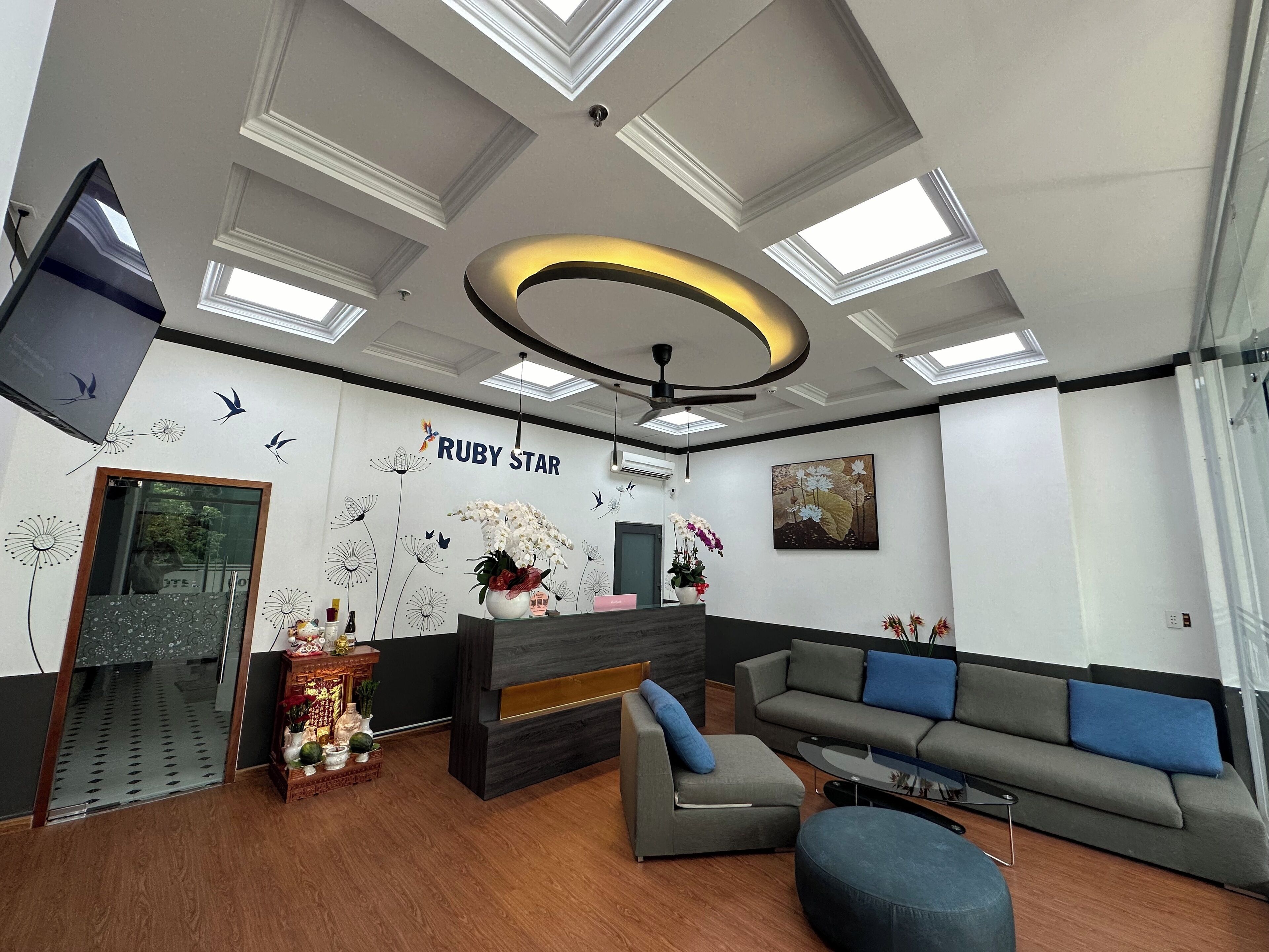 A modern reception area with a sofa, a desk, and a wall with 'RUBY STAR' signage.