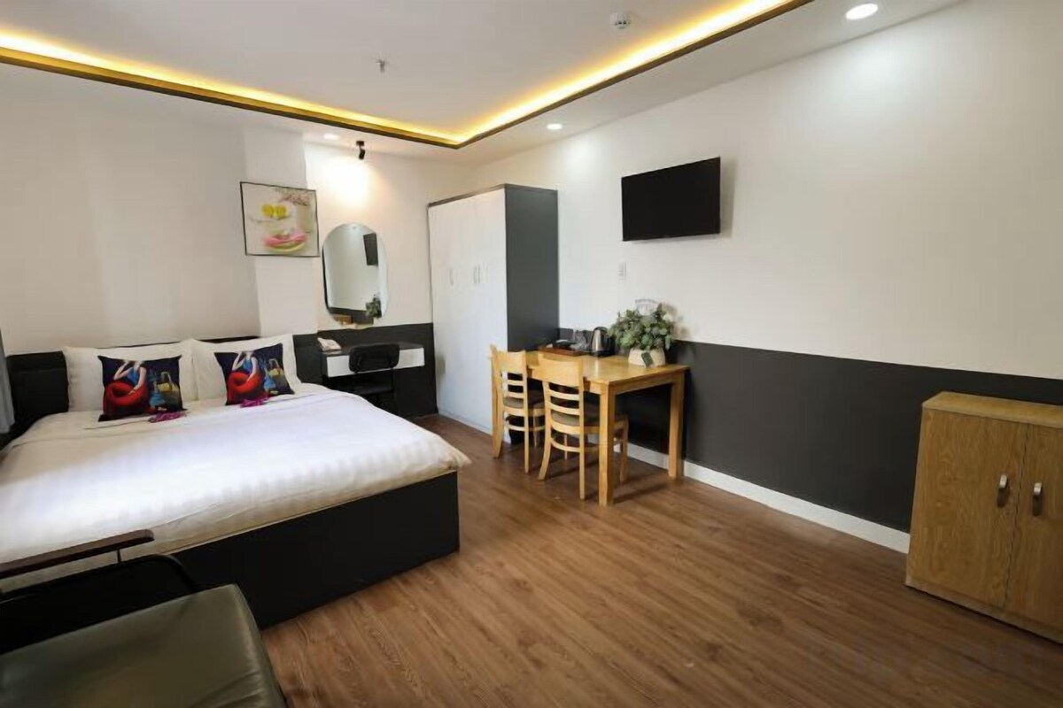 Un dormitorio moderno con cama, escritorio y armario.