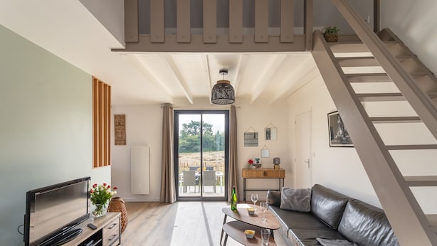 A modern living room with a TV, sofa, and dining area. - The Blue Rocks - Maison à moins d'1 km de la plage (Lamballe)