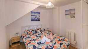 A bedroom with a bed, a nightstand, a lamp, and two wall art pieces.