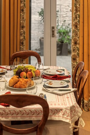 Une table à manger dressée avec des assiettes, des verres et une variété de plats.