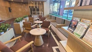 A modern lobby with seating areas, a reception desk, and a view of the outside. - Harbin Kunlun Hotel (Near Central Street & Harbin Railway Station) (Harbin)